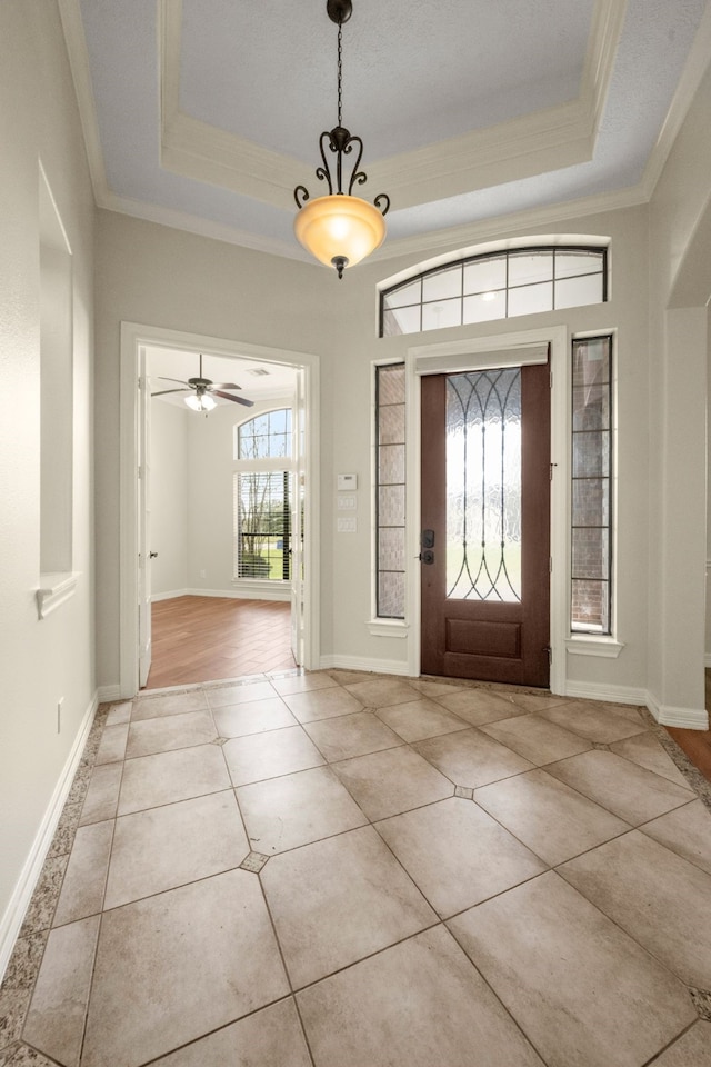 foyer featuring ceiling fan, plenty of natural light, light tile patterned floors, and ornamental molding