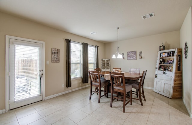 tiled dining room with a chandelier