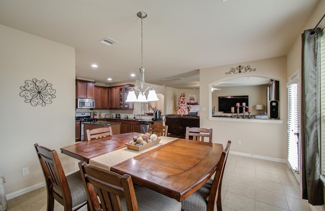 dining area with a chandelier, light tile patterned floors, and a wealth of natural light