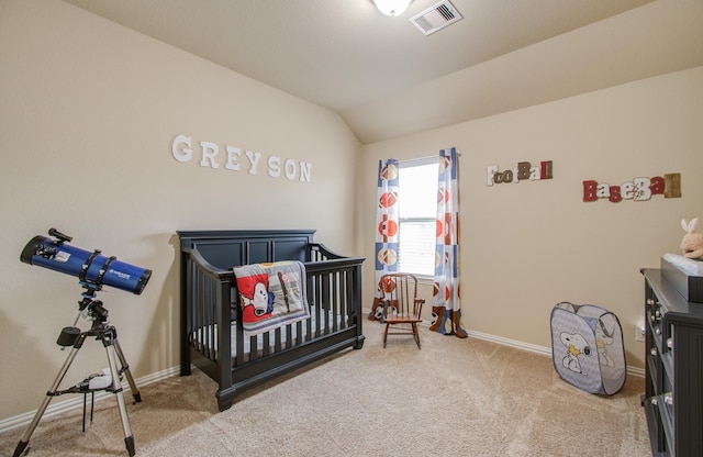 carpeted bedroom featuring vaulted ceiling and a nursery area