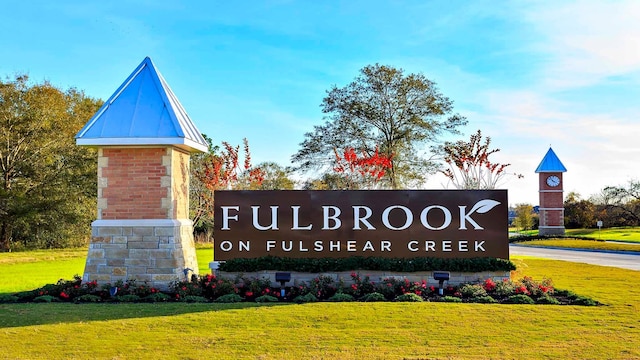 community / neighborhood sign featuring a lawn