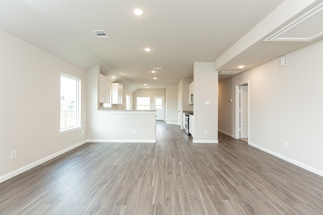 unfurnished living room featuring a healthy amount of sunlight and hardwood / wood-style flooring