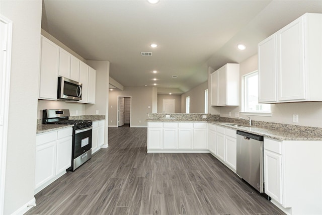 kitchen with dark wood-type flooring, white cabinets, stainless steel appliances, and sink