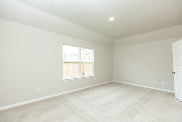 carpeted empty room with vaulted ceiling