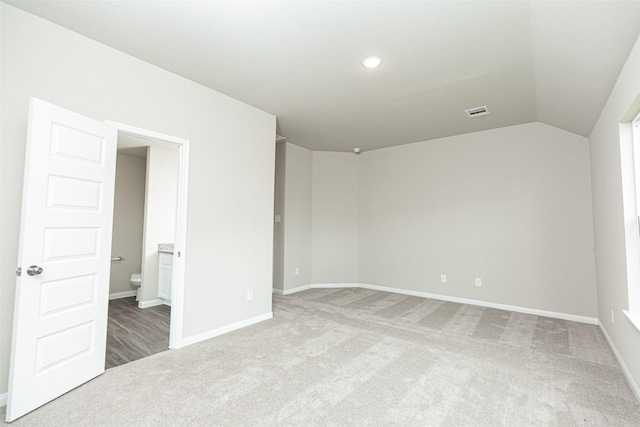 empty room with carpet floors and lofted ceiling