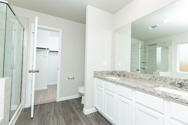 bathroom with vanity, hardwood / wood-style flooring, toilet, and an enclosed shower