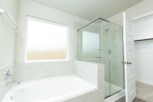 bathroom featuring separate shower and tub and a healthy amount of sunlight