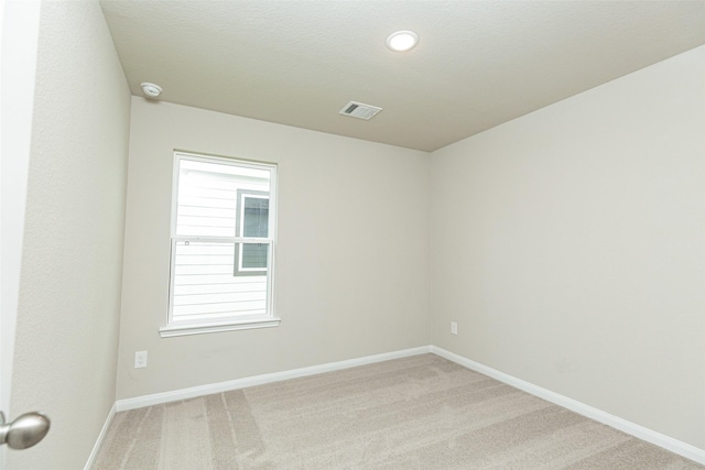 carpeted spare room with a textured ceiling