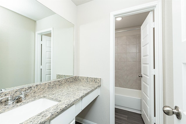 bathroom featuring vanity, hardwood / wood-style flooring, and tiled shower / bath