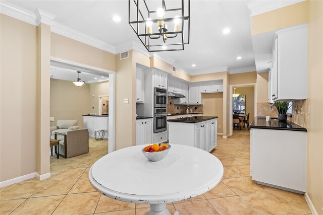 tiled dining area with a chandelier and ornamental molding