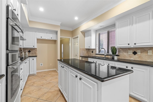 kitchen featuring a center island, backsplash, sink, and white cabinets