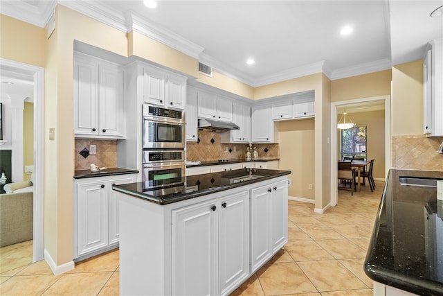 kitchen featuring crown molding, dark stone countertops, light tile patterned floors, a kitchen island, and white cabinetry