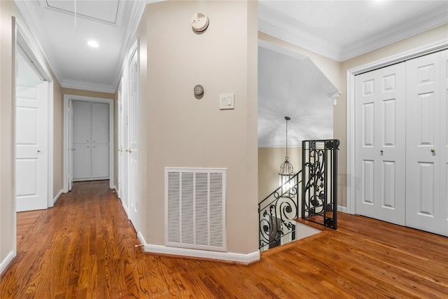 hall with wood-type flooring and ornamental molding