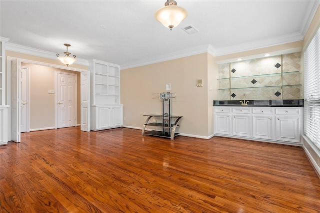 unfurnished living room with crown molding and hardwood / wood-style floors