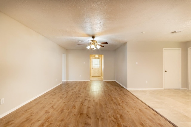 spare room with ceiling fan, light hardwood / wood-style flooring, and a textured ceiling