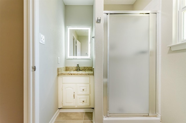 bathroom with tile patterned flooring, vanity, and a shower with door