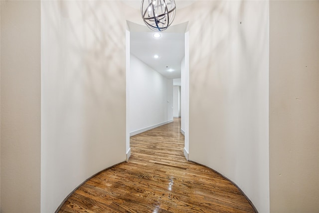 corridor featuring a chandelier and hardwood / wood-style flooring