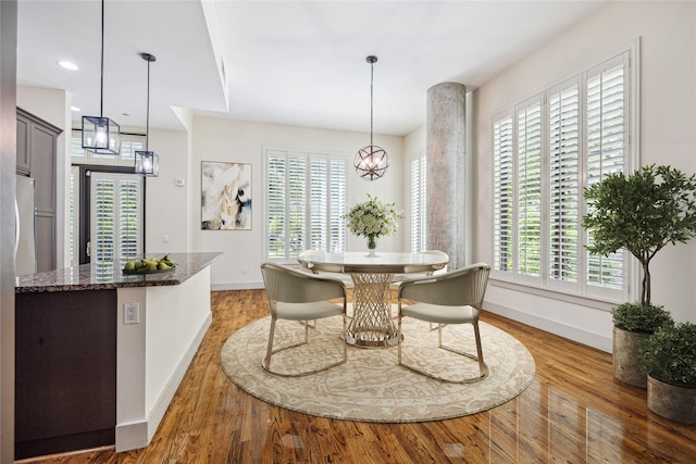 dining area with a notable chandelier, a healthy amount of sunlight, and wood-type flooring