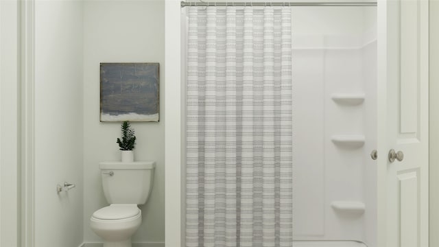 bathroom with curtained shower and toilet