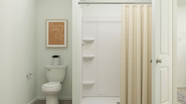 bathroom featuring a shower with curtain and toilet