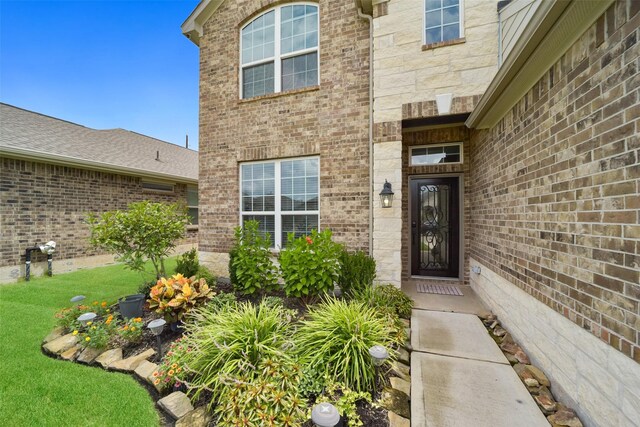 view of exterior entry with a yard