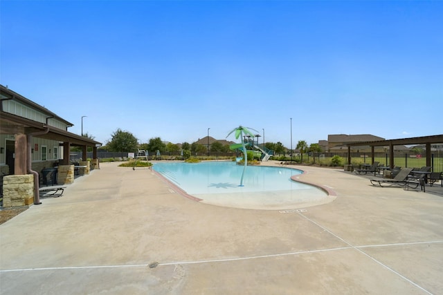 view of swimming pool featuring a water slide and a patio