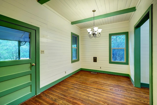 interior space featuring a chandelier, plenty of natural light, dark wood-type flooring, and wooden walls