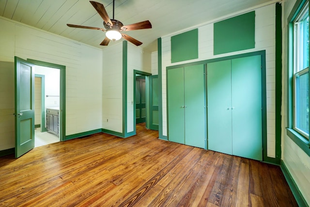 unfurnished bedroom featuring connected bathroom, ceiling fan, and hardwood / wood-style flooring