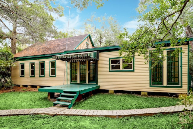 rear view of house with a lawn and a wooden deck