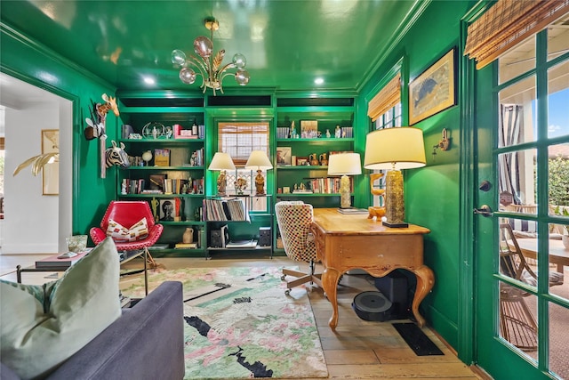 office area with a wealth of natural light, ornamental molding, and a notable chandelier