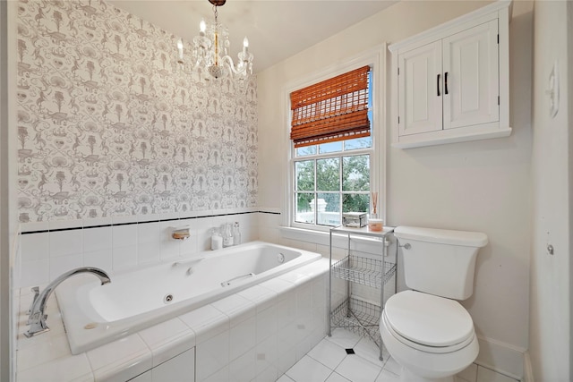 bathroom with tile patterned floors, tiled bath, a chandelier, and toilet