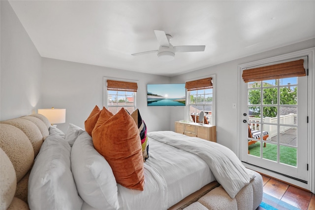 bedroom featuring light wood-type flooring, access to outside, multiple windows, and ceiling fan