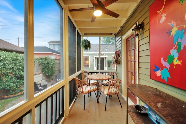 sunroom / solarium featuring ceiling fan and beam ceiling