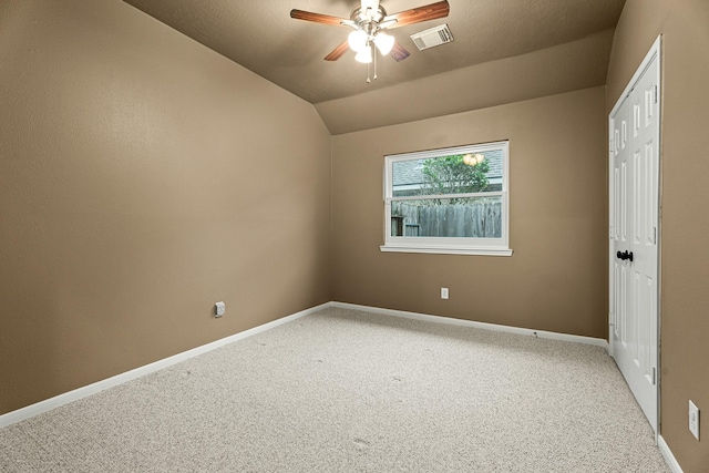 carpeted empty room with a textured ceiling, vaulted ceiling, and ceiling fan