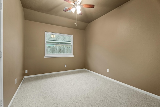 carpeted spare room featuring ceiling fan and vaulted ceiling