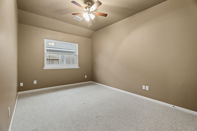 carpeted spare room with a textured ceiling, ceiling fan, and vaulted ceiling