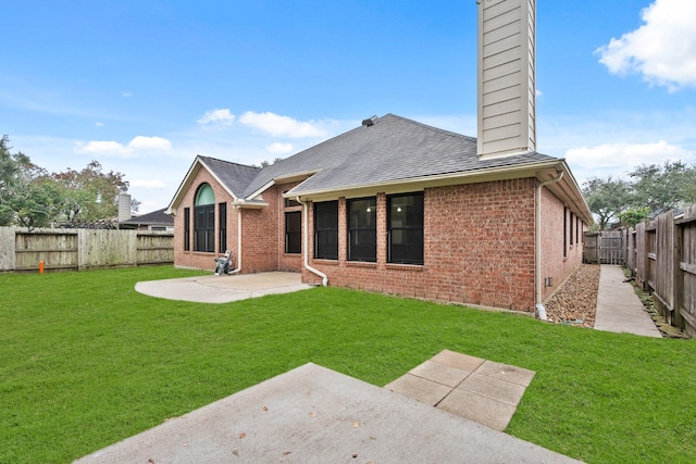 back of house featuring a lawn and a patio