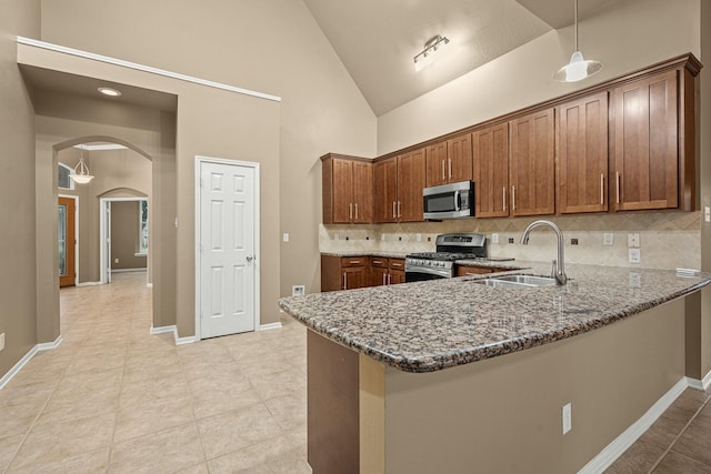 kitchen featuring backsplash, dark stone countertops, sink, and appliances with stainless steel finishes