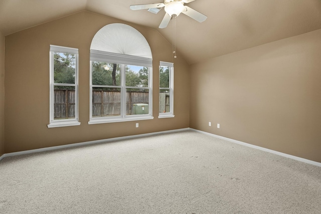 carpeted spare room with ceiling fan and vaulted ceiling