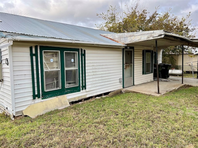 back of house with a lawn and a patio