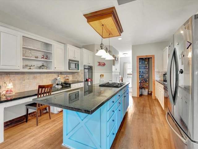 kitchen with white cabinets, appliances with stainless steel finishes, and decorative light fixtures