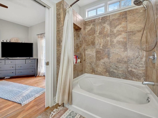 bathroom with hardwood / wood-style floors and shower / bathtub combination with curtain