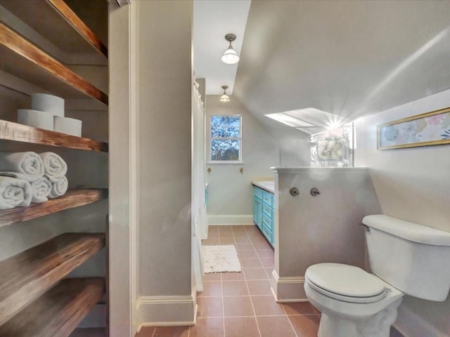 bathroom featuring tile patterned flooring, vanity, vaulted ceiling, and toilet