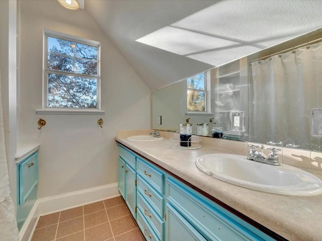 bathroom with a textured ceiling, vanity, and vaulted ceiling