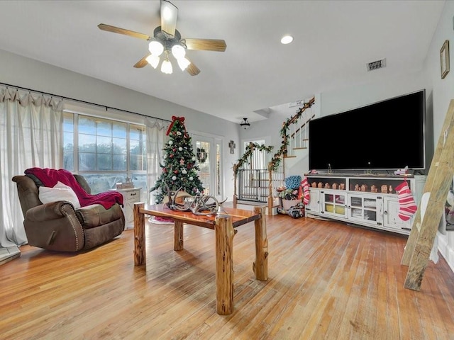 living room featuring ceiling fan and light hardwood / wood-style floors