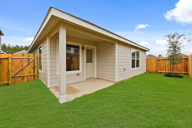 rear view of property with a lawn and a patio area