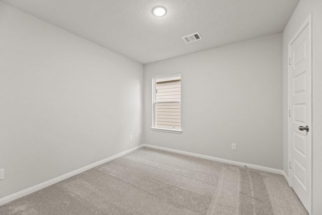 spare room featuring carpet flooring and a textured ceiling