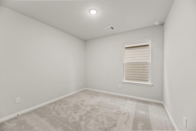 empty room featuring light carpet and a textured ceiling