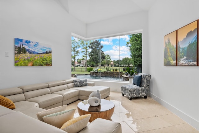 living room featuring light tile patterned floors and a water view