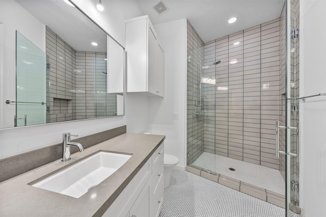 bathroom featuring tile patterned flooring, vanity, a shower with door, and toilet